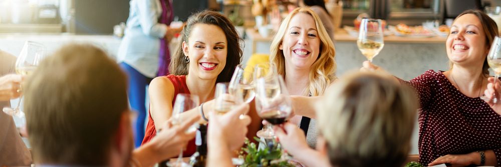 Group of people toasting with wine glasses at a celebration. Smiling friends enjoying a festive gathering. Cheers and…