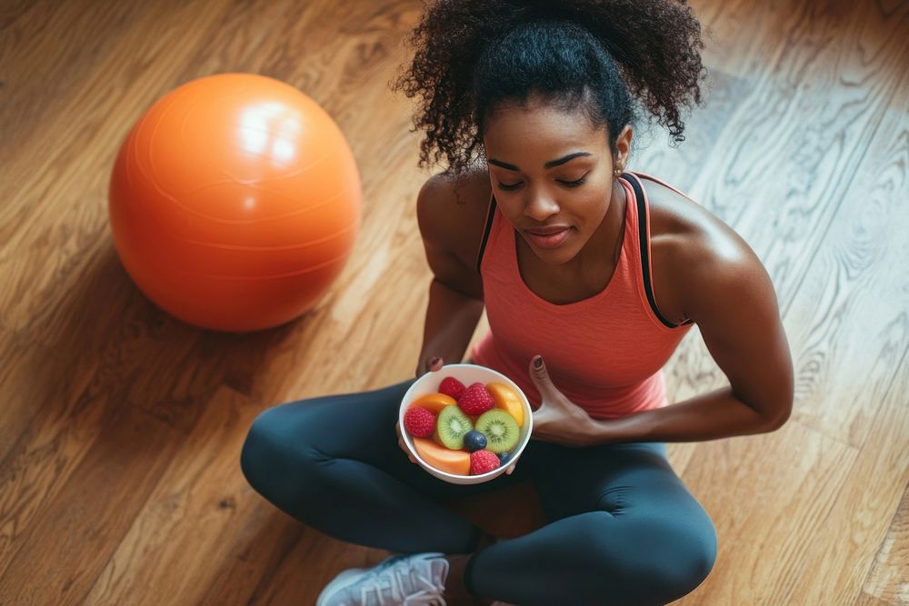 Sporty black young woman bowl ball sitting.