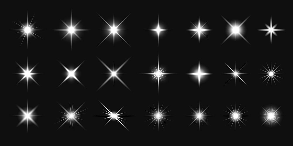 Collection of white starburst light effects on a black background. Starburst patterns vary in size and intensity. Perfect…