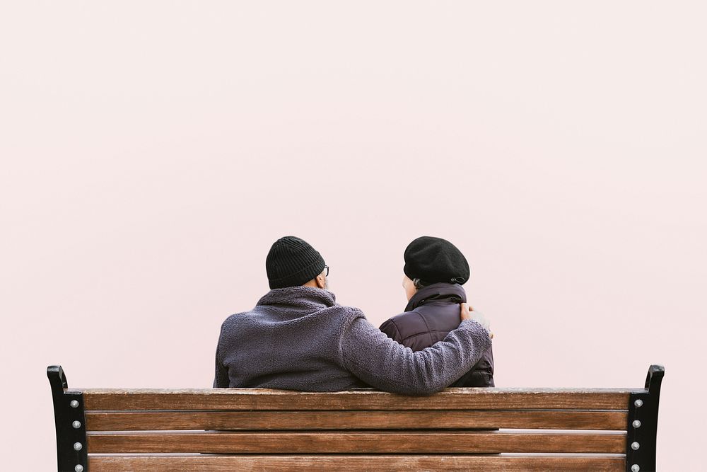 Senior couple on park bench, isolated on pink psd