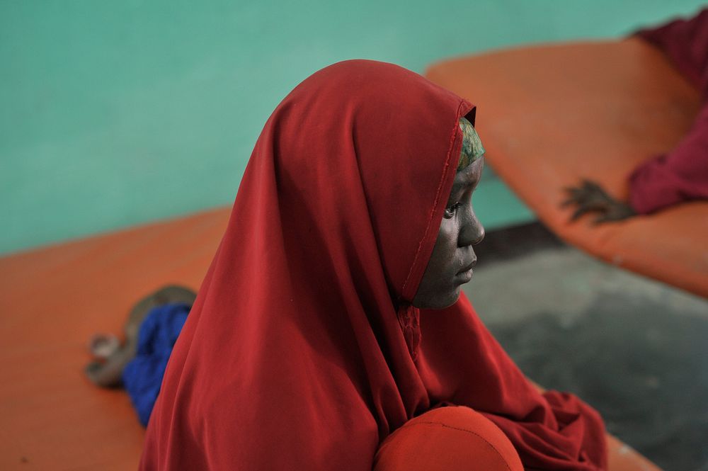 A woman sits on a bed with her sick child at a hospital run by Dr. Hawa in the Afgoye corridor of Somalia on September 25.