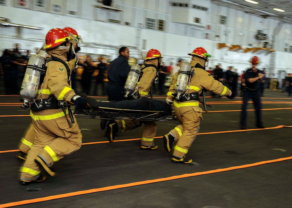 U.S. Sailors compete in a firefighting relay event as part of a damage control Olympics aboard the aircraft carrier USS…