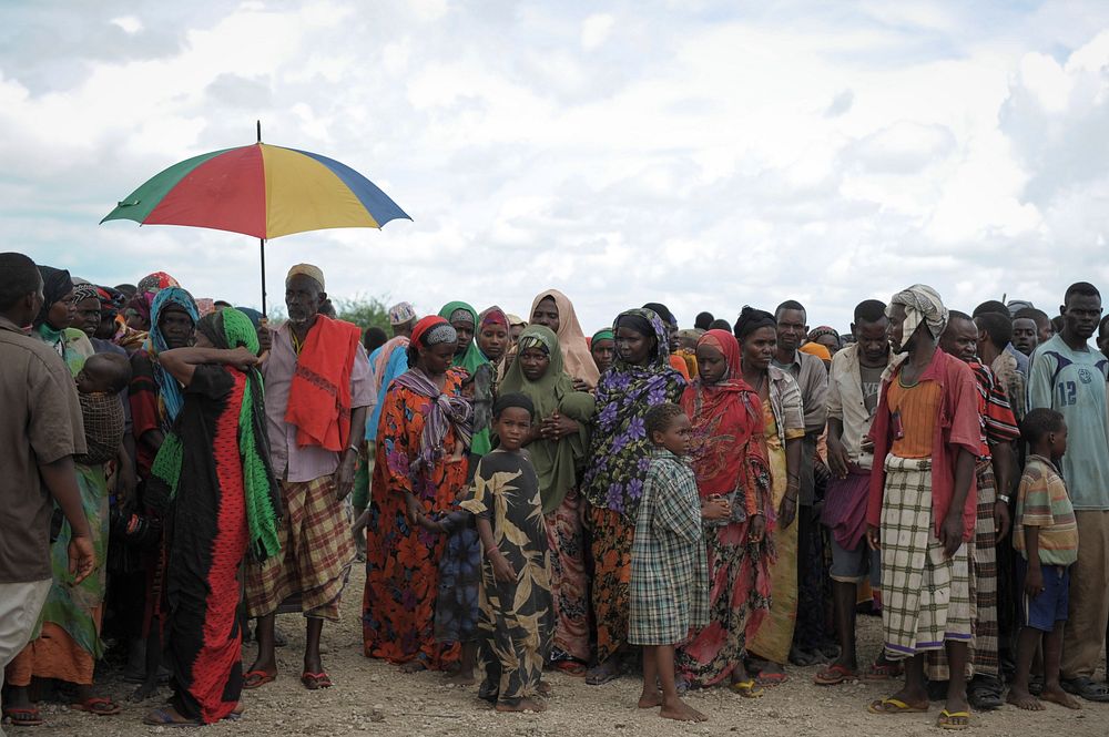 Internally Displaced People, affected by flooding and clan conflict, wait for a food handout at an AMISOM military camp near…