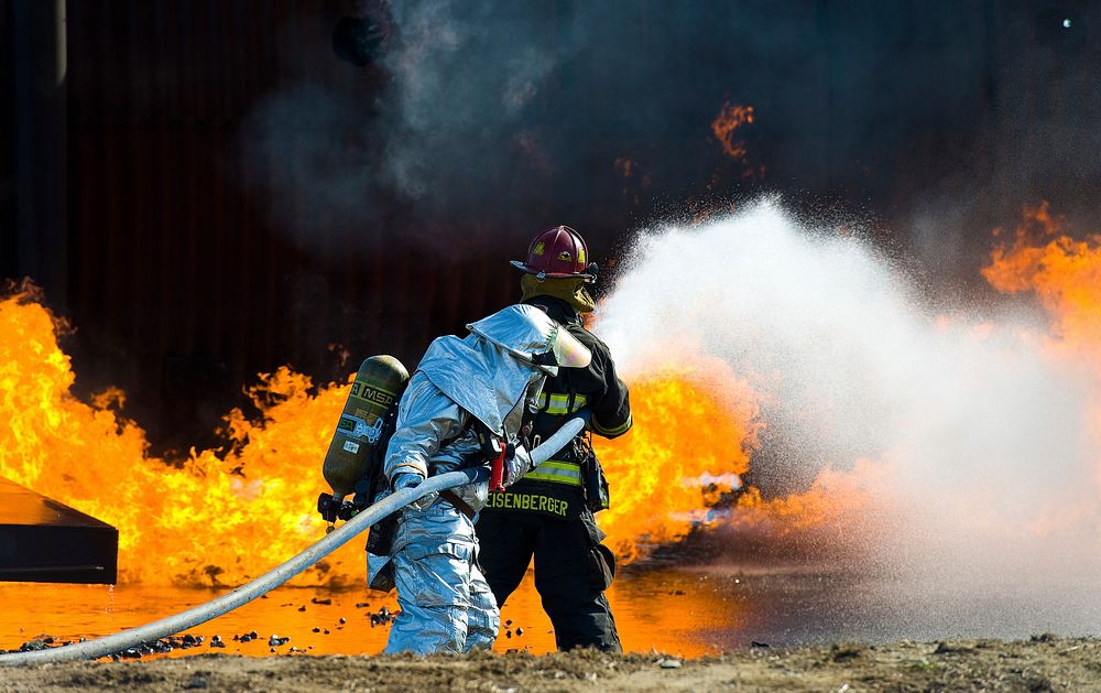 Aaron Weisenberger, front, with the 436th Civil Engineer Squadron fire department, leads a two-person fire attack crew…