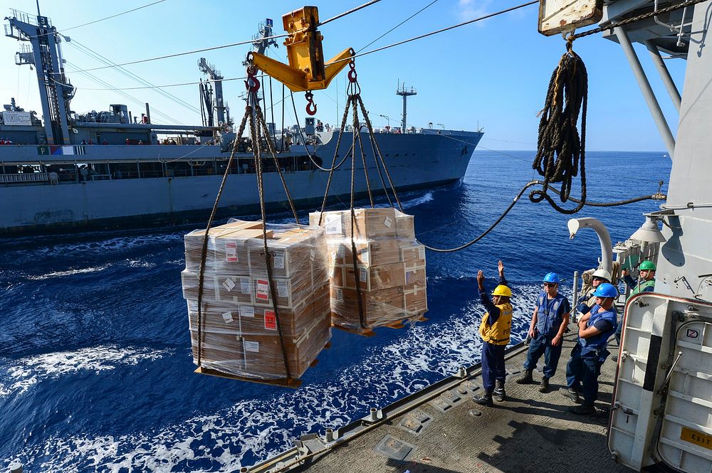U.S. Sailors aboard the guided missile cruiser USS Monterey (CG 61) prepare to receive cargo from the fleet replenishment…