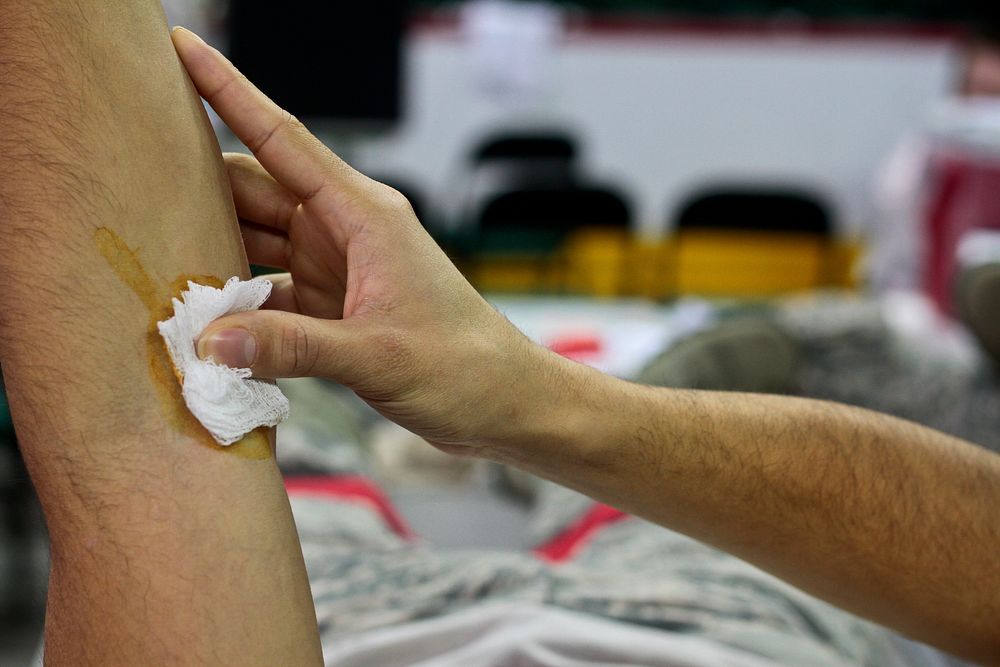 U.S. Air Force airman puts pressure on his arm after donating blood. Original public domain image from Flickr