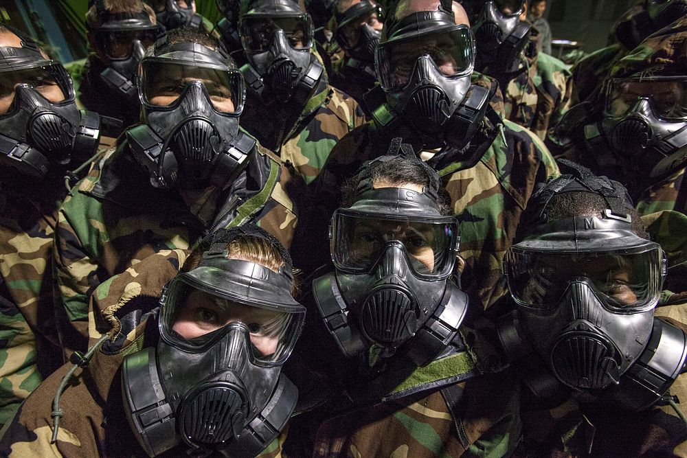 U.S. Airmen with the 108th Wing, New Jersey Air National Guard don M50 masks as they review topics such as chemical…