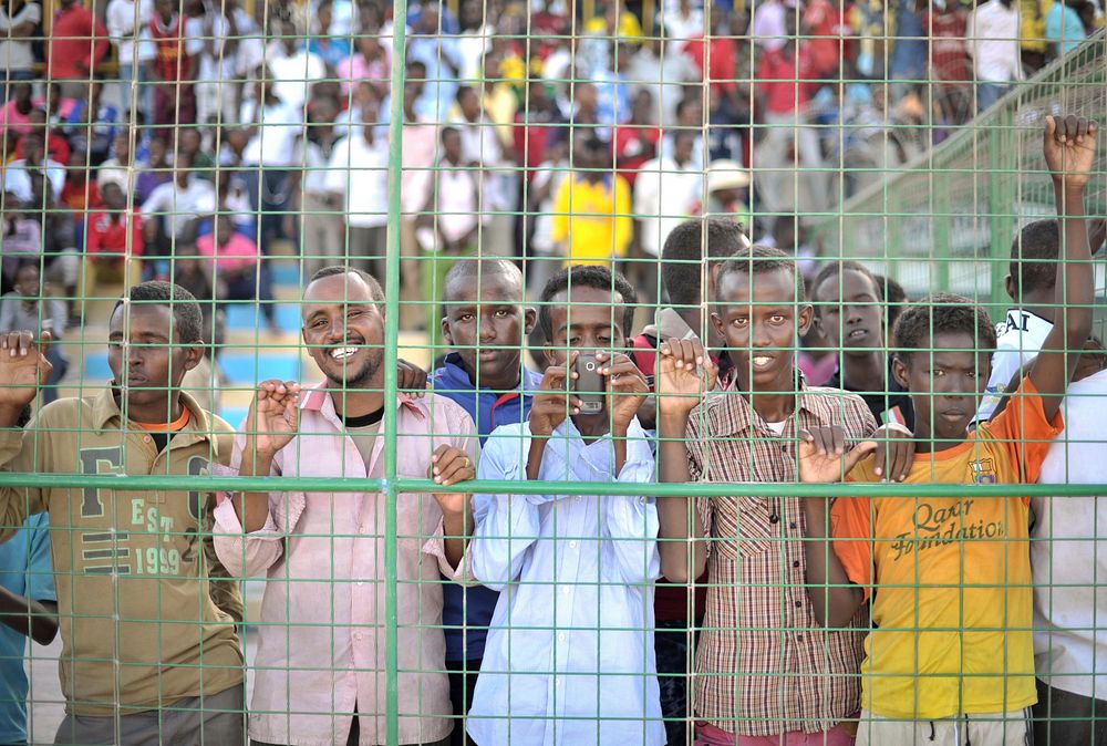 Young men watch a football match in Mogadishu, Somalia, between the Somali Police Force and the Somali National Army on…