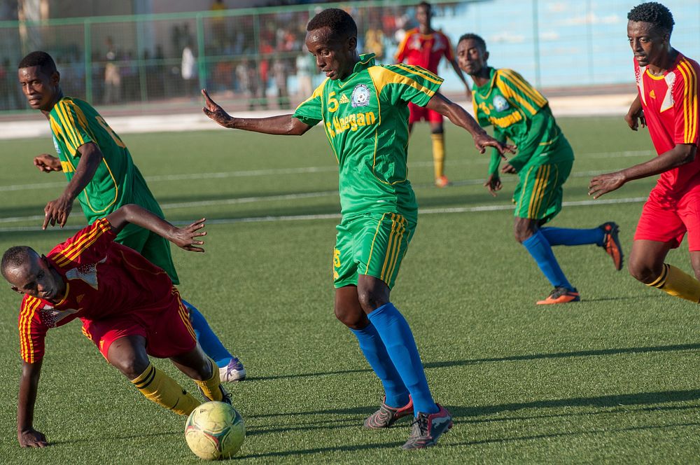 A Horseed player stumbles as a Heegan player tries to steal the ball during a game between Heegan and Horseed football clubs…