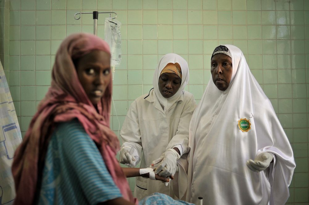 Two midwives put a drip into one of their patients in the maternity ward of Banadir hospital in Mogadishu, Somalia, on…