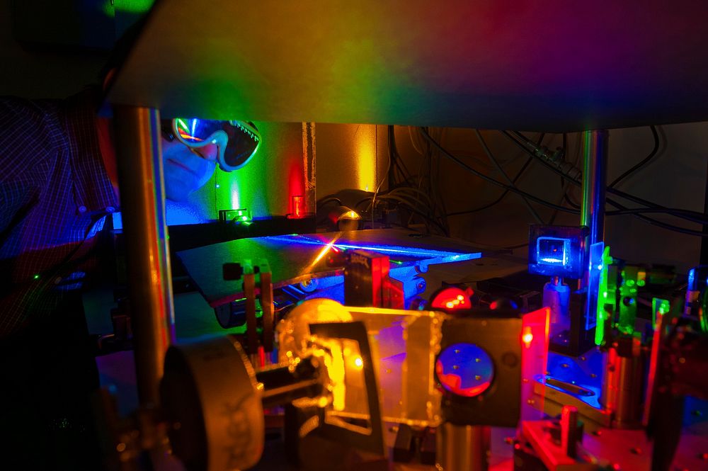 A Sandia researcher examines the set-up used to test diode lasers as an alternative to led lighting. Original public domain…