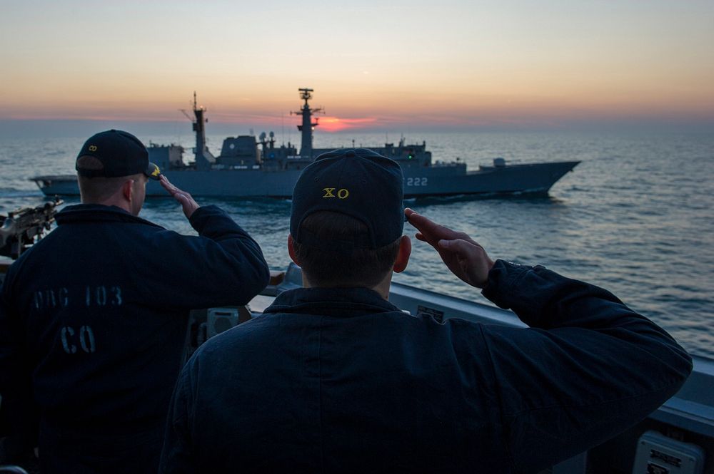 U.S. Navy Cmdr. Andrew Biehn, right, the commanding officer of the guided missile destroyer USS Truxtun (DDG 103), and Cmdr.…