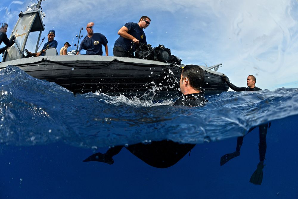 U.S. Navy divers with Mobile Diving and Salvage Unit 1 assist Coast Guard divers following a scuba dive in the Pacific Ocean…
