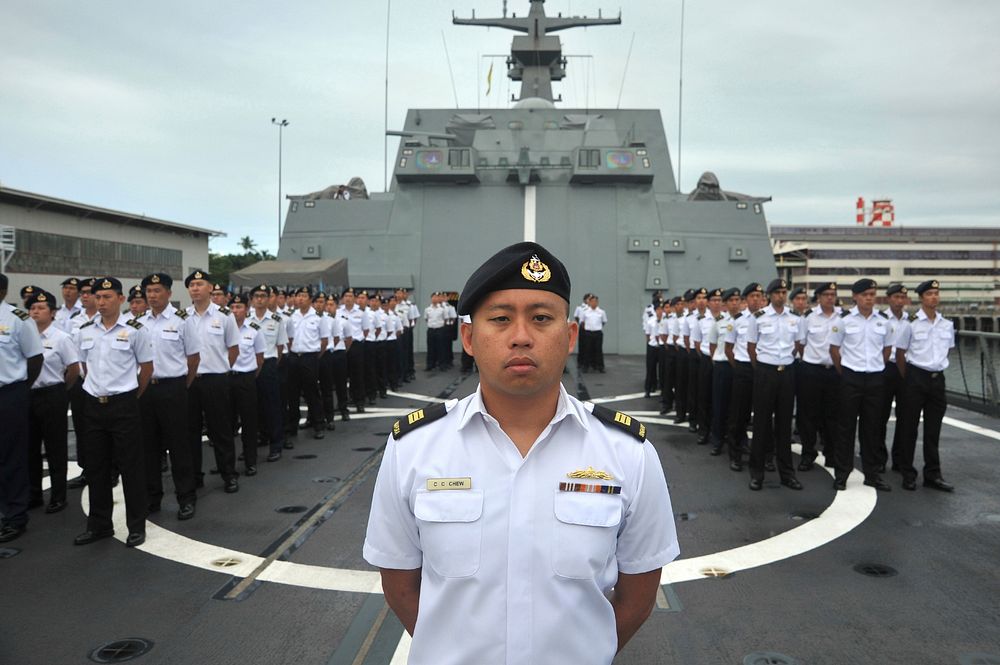 Singapore service members stand by for morning colors aboard the frigate RSS Intrepid (F 69) at Joint Base Pearl Harbor…