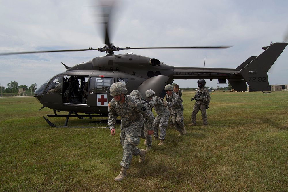 U.S. Soldiers with the 1077th Ground Ambulance Company, Kansas Army National Guard clear the area after loading a patient…