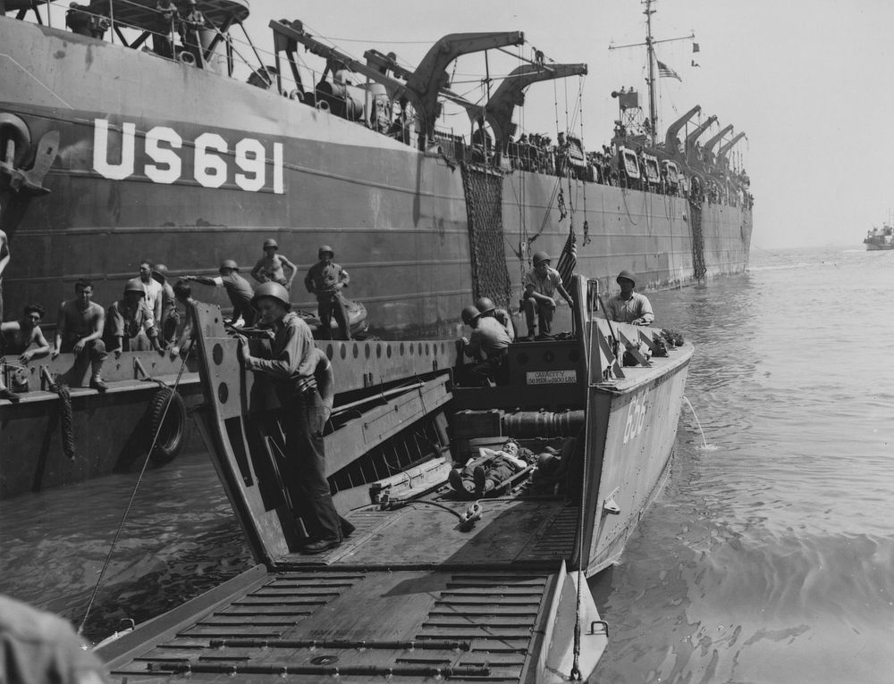 LST's bring men and supplies to beach on southern France. LST 691 in foreground, LCU 656 carrying wounded men to ship for…