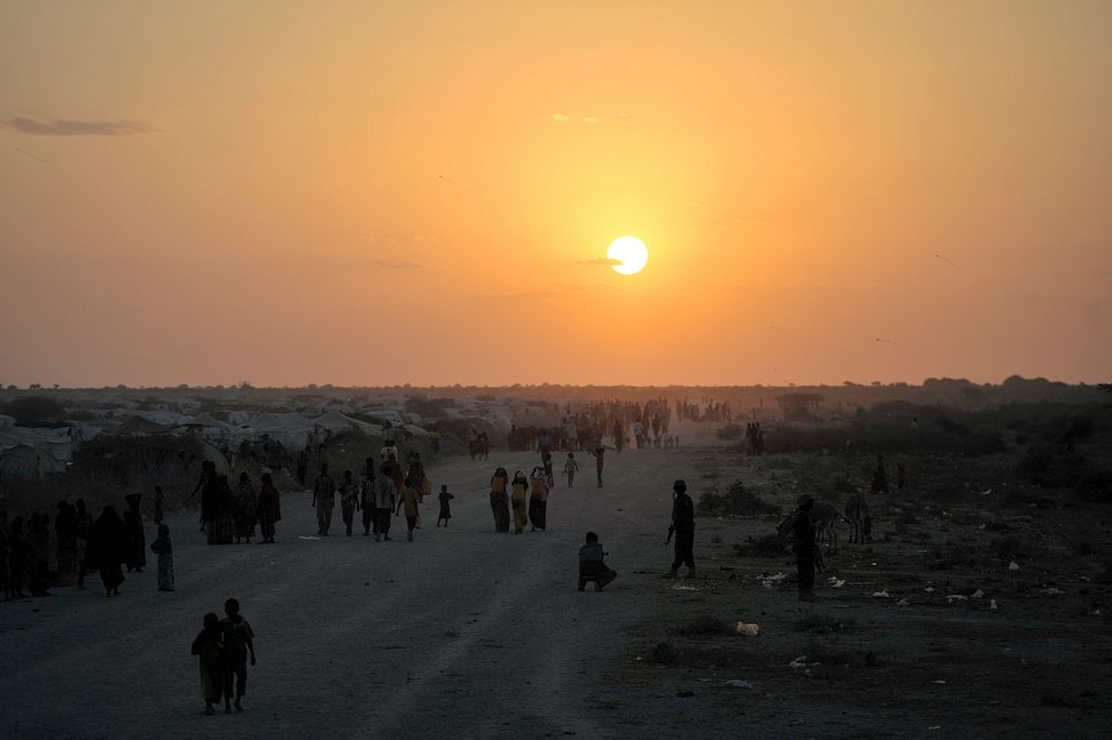 People walk along the road next to an IDP camp near the town of Jowhar, Somalia, on December 14.