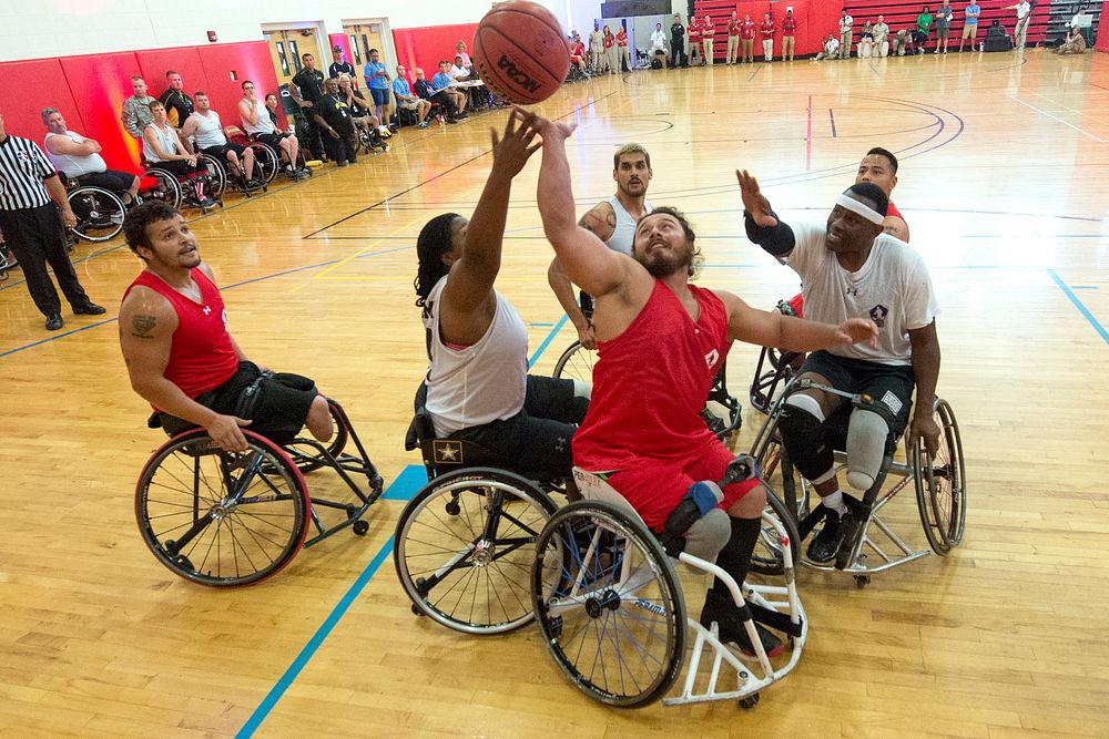 Teams Marine Corps and Army battle for a rebound during wheelchair basketball preliminary rounds for the 2015 Department of…