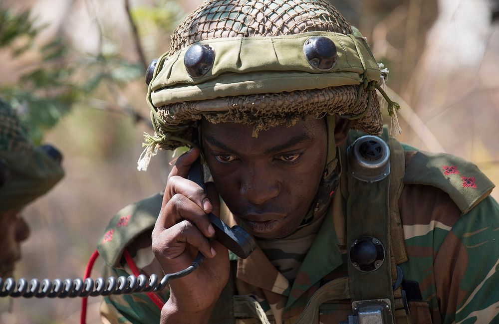 A soldier with the Zambian Defense Force radios in to command post after receiving contact from simulated adversaries during…