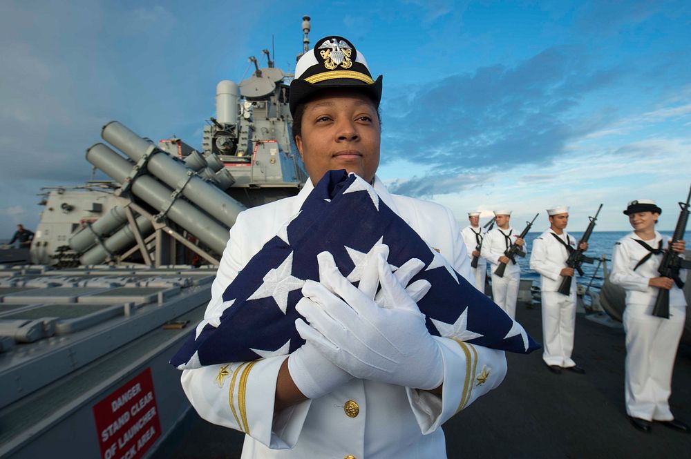 MEDITERRANEAN SEA (Oct. 24, 2015) Lt. j.g. Simone Mims, from New London, Connecticut, holds the national ensign in…