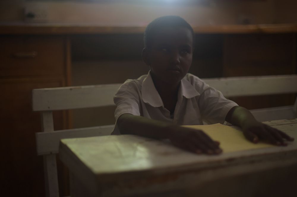 A young child with impaired vision listens while his teacher speaks in class at the Al-Nor School for the Blind in…