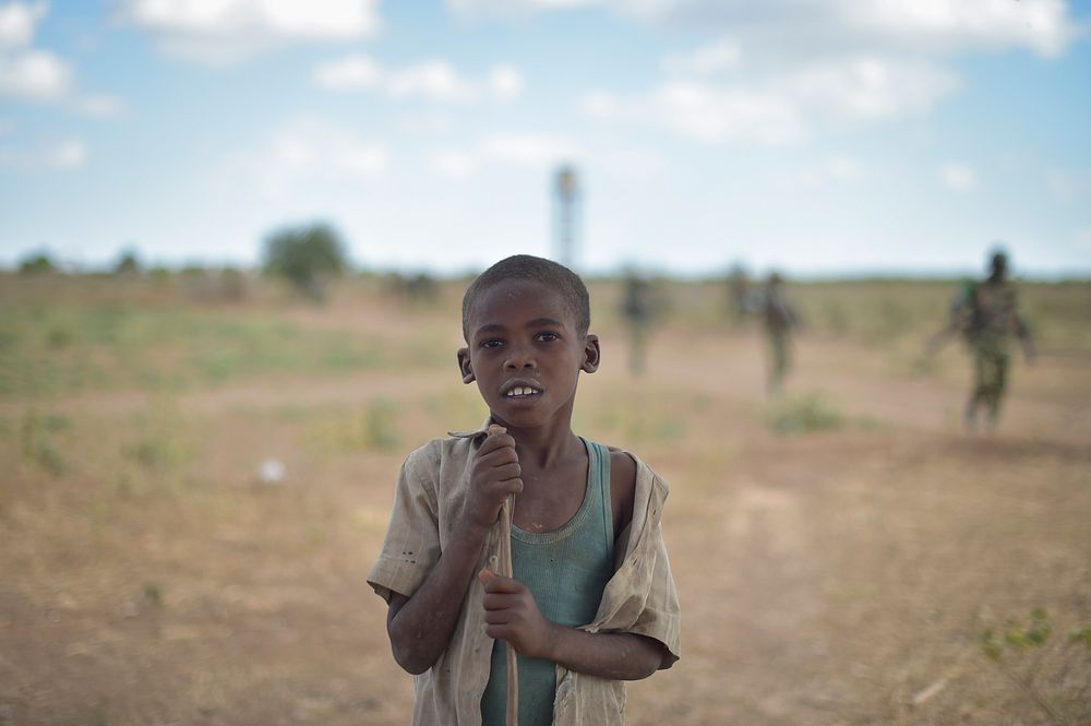 A young boy poses for the camera as Burundian trooops, part of the Afrian Union Mission in Somalia, patrol the countrside…