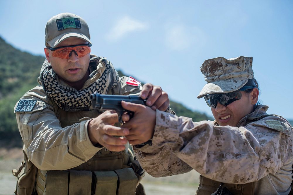 Canadian Army Cpl. Brett Finkle, left, assigned to Canadian Forces Combat Camera, assists U.S. Marine Corps Lance Cpl.…