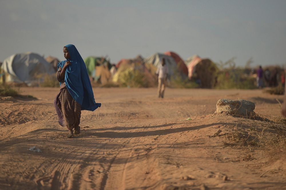 A young Somali girl walks through an IDP camp near the town of Beletweyne, Somalia, on May 28, 2016.