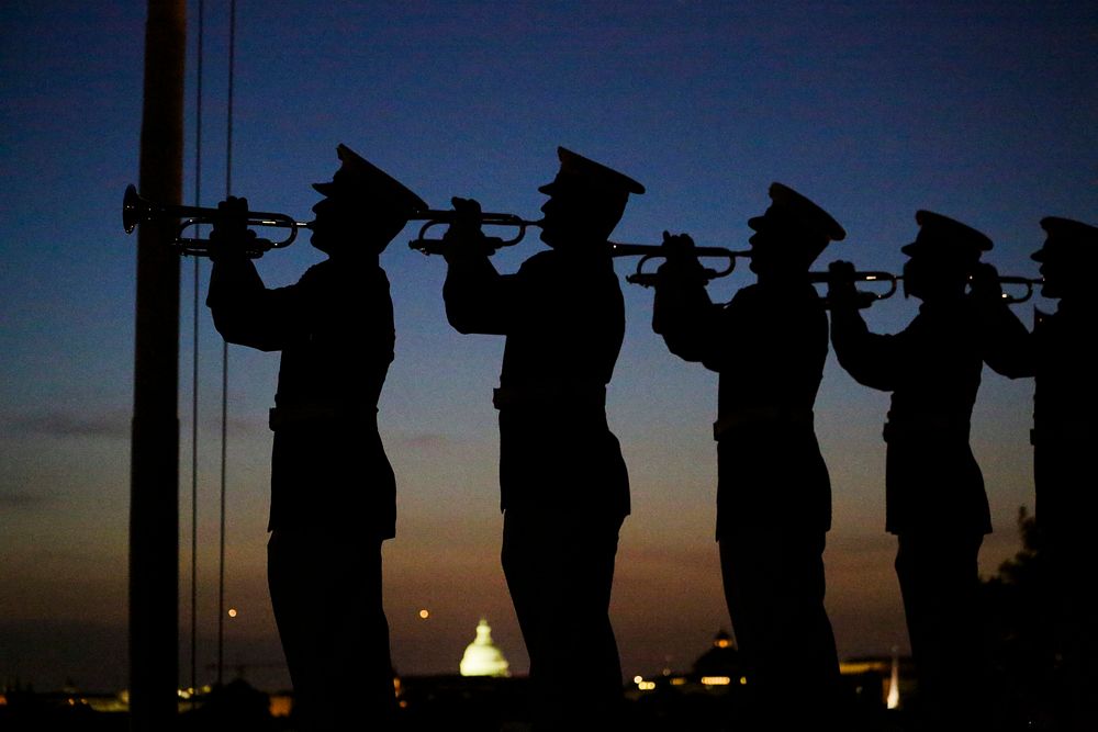 U.S. Marines with 'The Commandant’s Own' U.S. Marine Corps Drum & Bugle Corps play Taps during a Friday Evening Parade at…