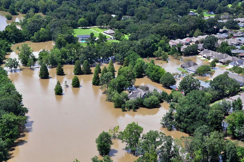 An aerial view taken from an MH-65 Dolphin helicopter shows severe flooding in a residential area of Baton Rouge, LA on Aug.…