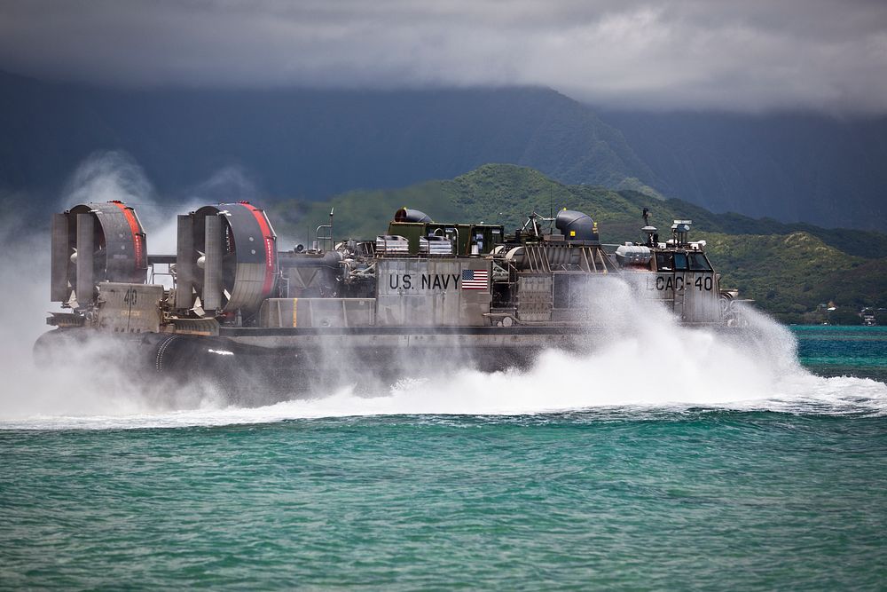 A U.S. Navy Landing Craft Air Cushion (LCAC) assigned to Assault Craft Unit 5 leaves shore during a loading exercise at…