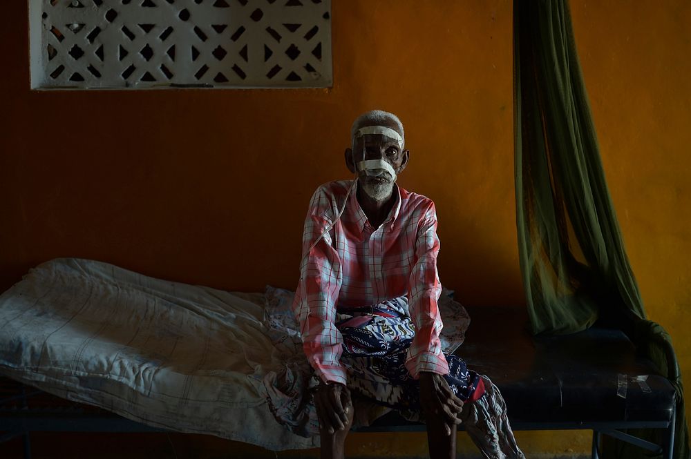 An elderly Somali man, thought to be suffering from cancer, sits on his bed at a ward in Barawe's hospital on August 23…