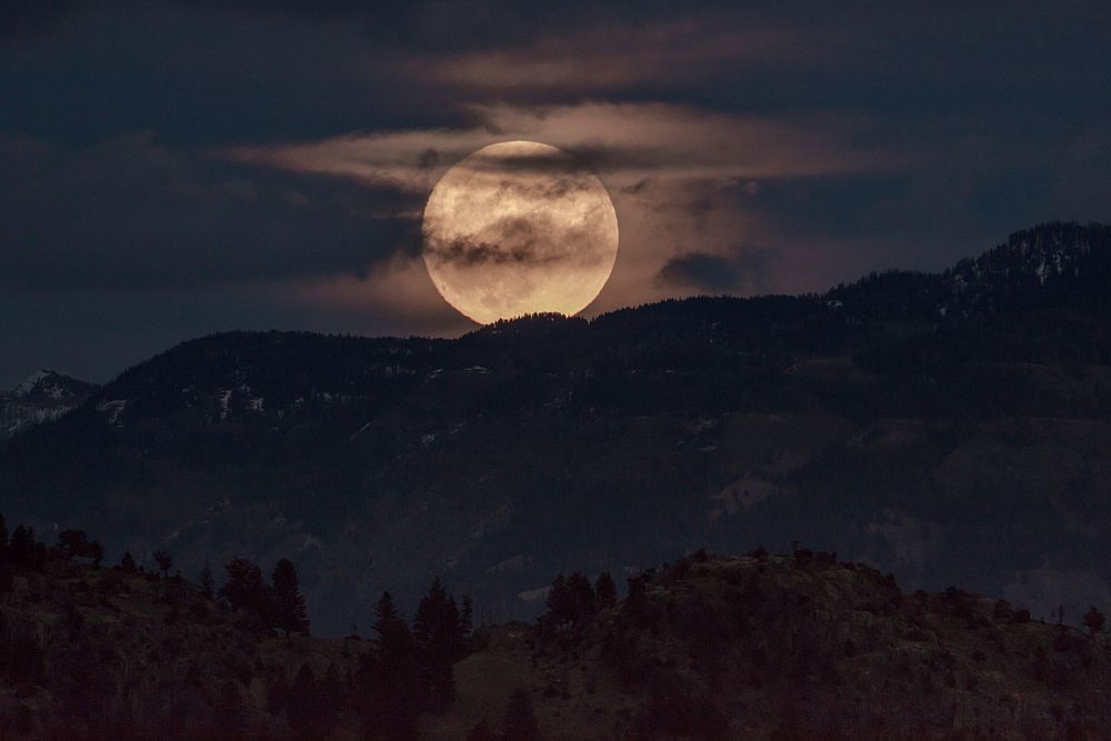 Super moon over mountain range at night. Original public domain image from Flickr