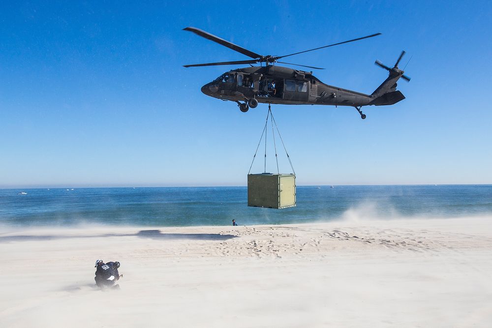 New Jersey State Police protect themselves from the blasting sand from a UH-60 Black Hawk with the 1-150th Assault…