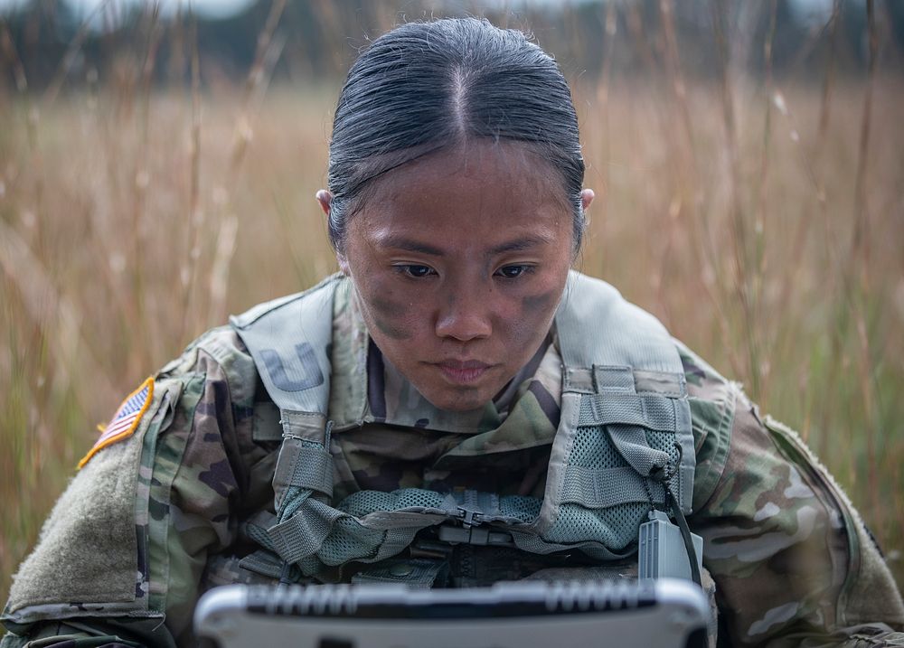 U.S. Army 2nd Lt. Fatima Agilar, a platoon leader with the 328th Military Police Company, works to connect a laptop to a…