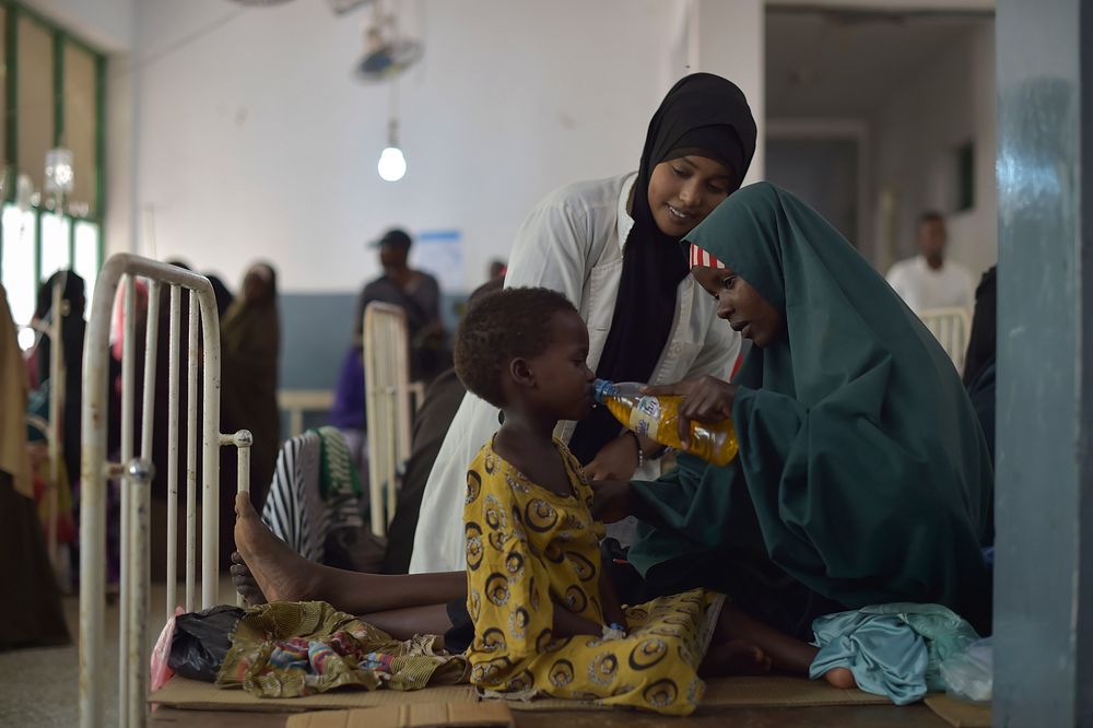A mother gives her daughter a drink full of rehydrating salts at Banadir hospital in Mogadishu, Somalia, on March 9, 2017.