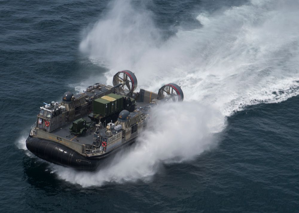 A U.S. Navy Landing Craft, Air Cushion hovercraft transports Marines and equipment with Special Purpose Marine Air-Ground…