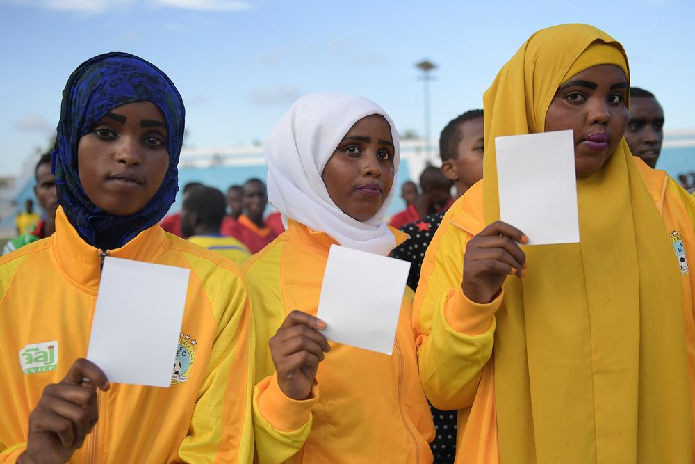 Somalia ladies hold white cards as symbols of peace, at a ceremony to mark International Sports Day for development and…