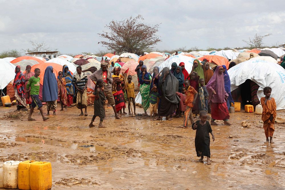 Mothers with their children stand in front of their makeshift houses at Maqori Manyow Camp for Internally Displaced Persons…