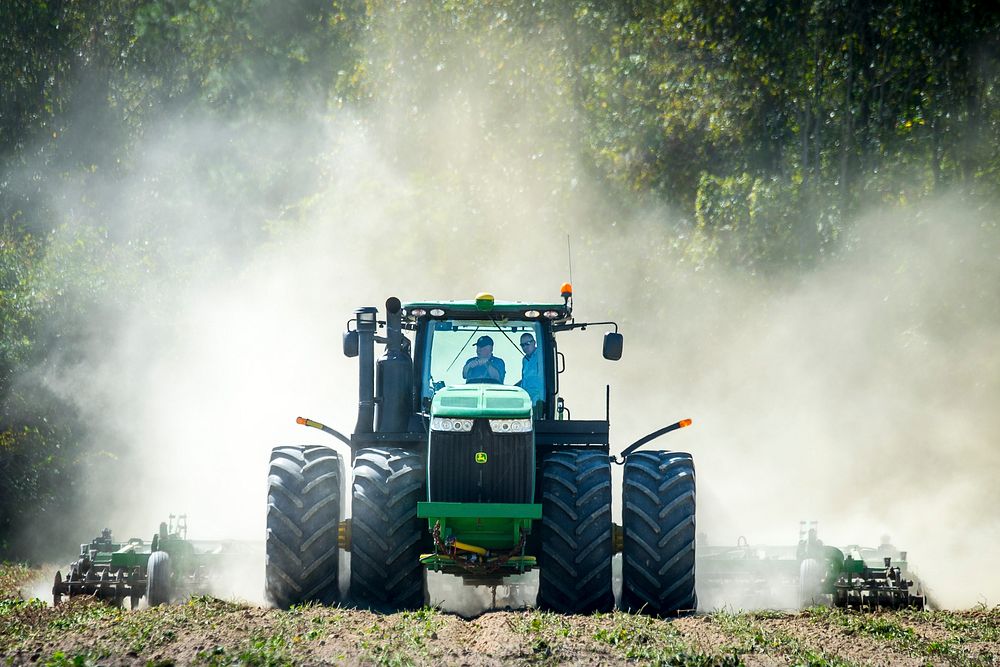 U.S. Department of Agriculture (USDA) Secretary Sonny Perdue drives a tractor through a sweet potato field with Linwood…