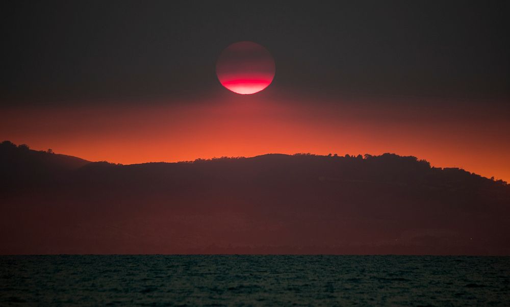 Beautiful sun setting over mountain range. Original public domain image from Flickr