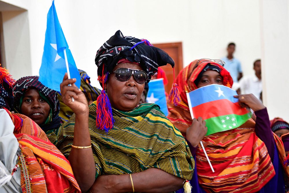 Women wave flags to welcome the Special Representative of the United Nations Secretary-General (SRSG) for Somalia, Michael…