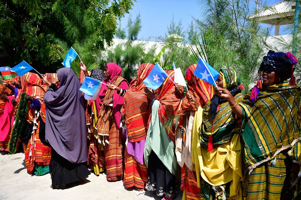 Women wave flags to welcome the Special Representative of the United Nations Secretary-General (SRSG) for Somalia, Michael…