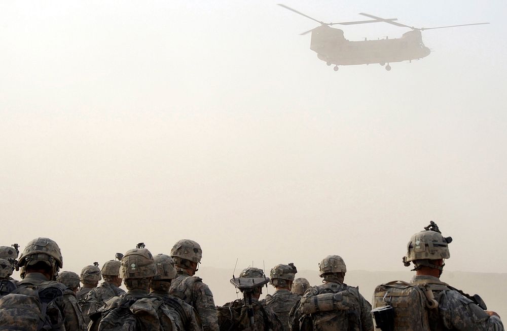 U.S. Army paratroopers watch as a CH-47 Chinook helicopter descends to pick them up for an air-assault mission July 17…