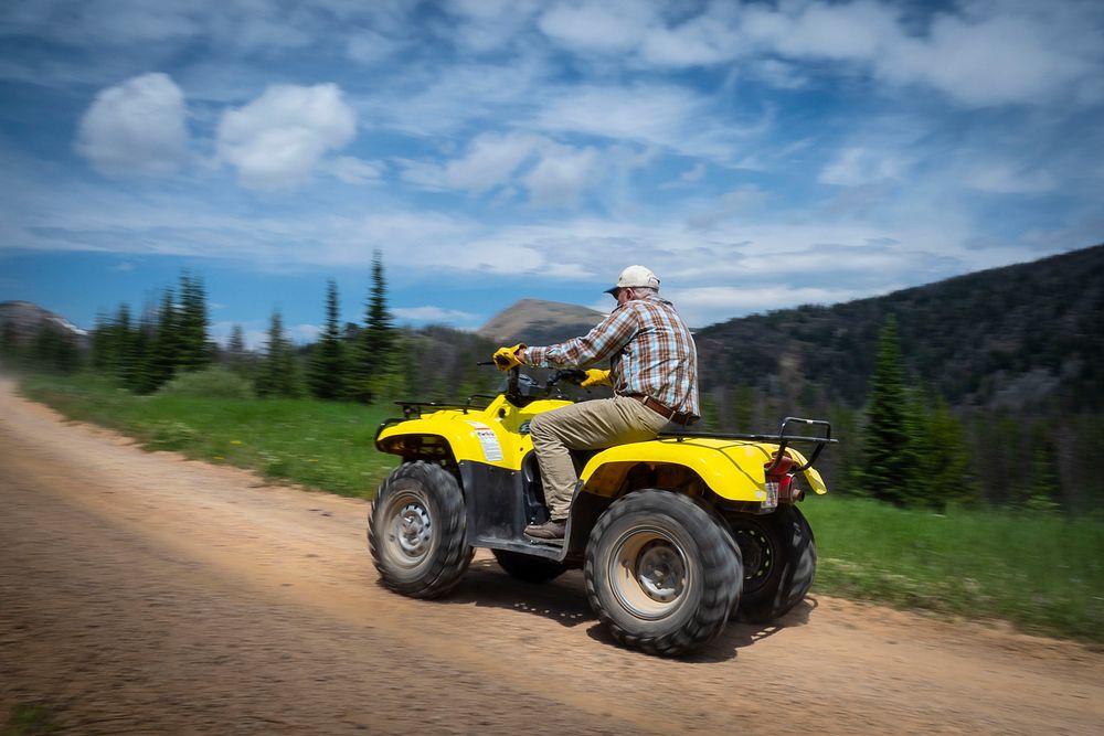 A elderly man rides his all-terrain vehicle (ATV) with his family in the Gravelly Mountain Range of Beaverhead-Deerlodge…