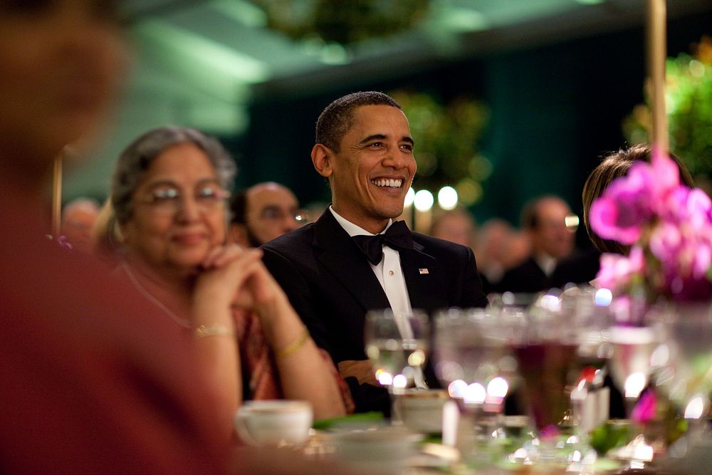 President Barack Obama smiles while watching the entertainment at the State Dinner for Prime Minister Manmohan Singh of…