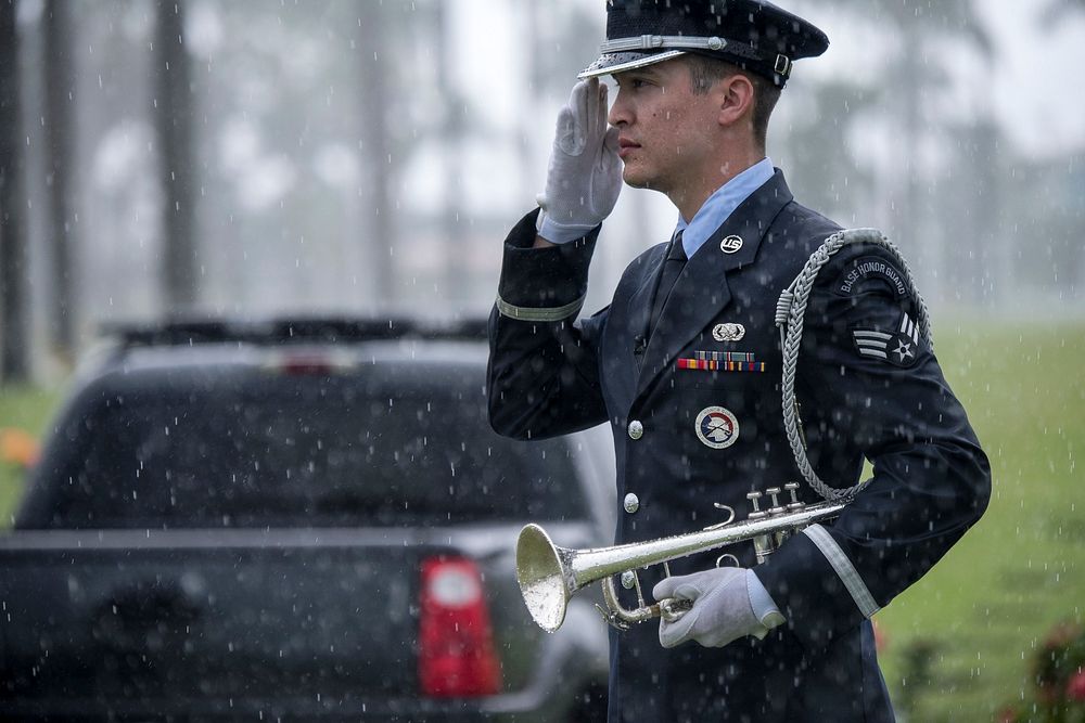 U.S. Air Force Senior Airman Gabriel Fox, Joint Base Langley Honor Guard, renders a salute after playing taps on a bugle…