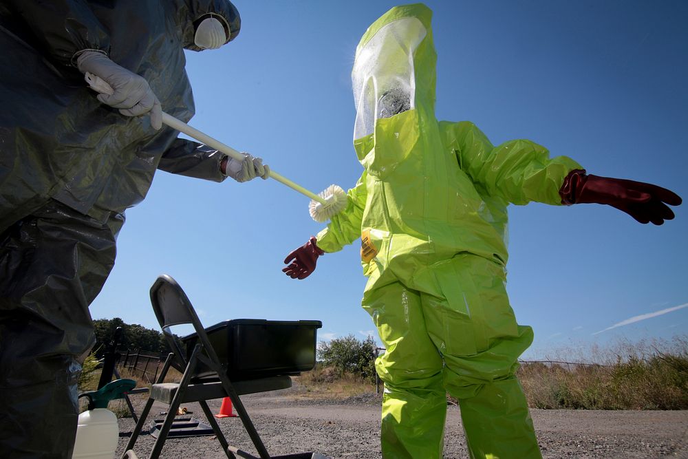 U.S. Air National Guard Senior Airman is decontaminated by Airman during Exercise Clean House. Original public domain image…