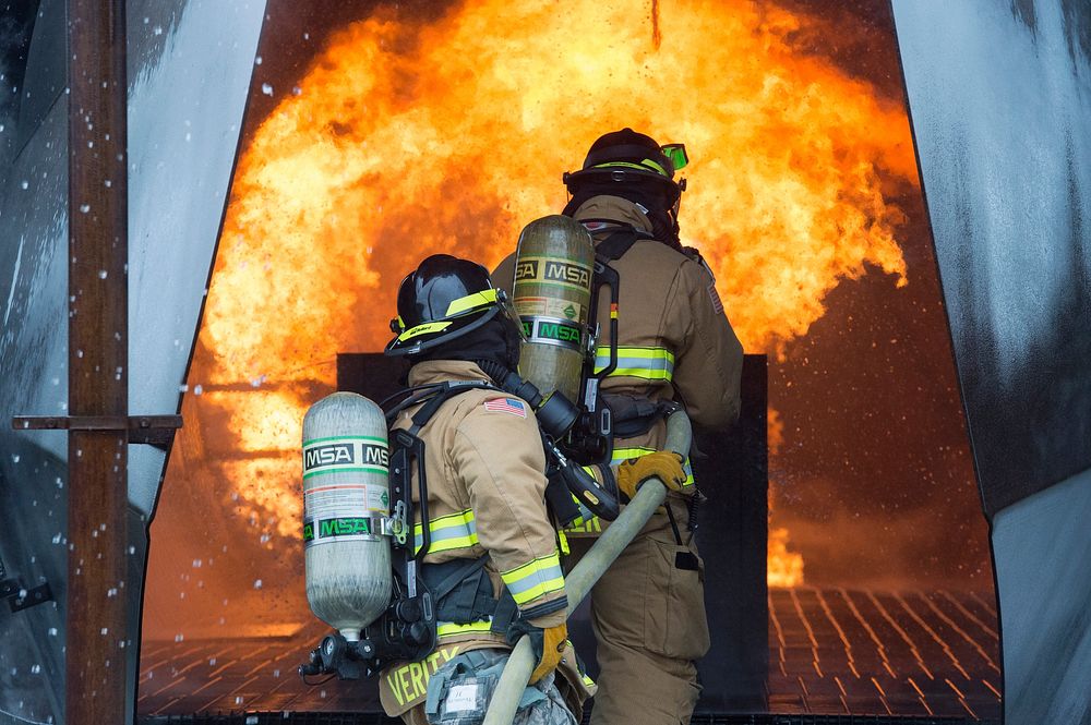 U.S. Air Force Airman 1st Class Collin Saumier, lead, and Staff Sgt. Robert Verity, rear, fire protection specialists…