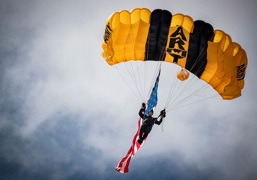 A U.S. Army Soldier with the Golden Knights Parachute Demonstration Team comes in for a landing on the beach during the…